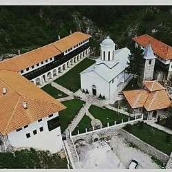 Српски Православни Манастир Свете Тројице у Пљевљама - Величанствени поглед на главни манастирски храм Свете Тројице у Пљевљима са аутентичном средњовековном архитектуром и високим каменим зидинама које чувају духовни мир ове српске православне светиње из доба Немањића