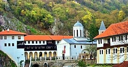 Манастир Свете Тројице Пљевља - Панорамски поглед на спољашњу архитектуру манастира Свете Тројице у Пљевљима са високим каменим зидовима и препознатљивим звоником из даљине  Главни храм манастира Свете Тројице Пљевља посматран са улазне капије при чему се види складна градња од камена и специфичан кровни покривач одозго  Архитектонски приказ храма Свете Тројице у Пљевљима окруженог зеленим падинама брда Голубиња са јасно видљивим апсидама и фасадом у крупном плану